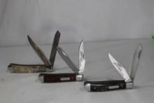 Three Imperial Schrade trapper knives with stainless steel blades, one with acrylic swirl scales,