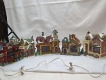 CHRISTMAS VILLAGE GROUP WITH SANTA'S WORK SHOP, COFFEE SHOP, SCHOOL, FIRE STATION, AND A HOME.