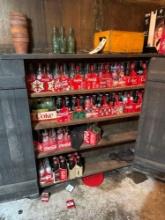 several cases of Coca-Cola bottles, crates and memorabilia