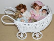 Four Small Porcelain Dolls in Wicker Cart